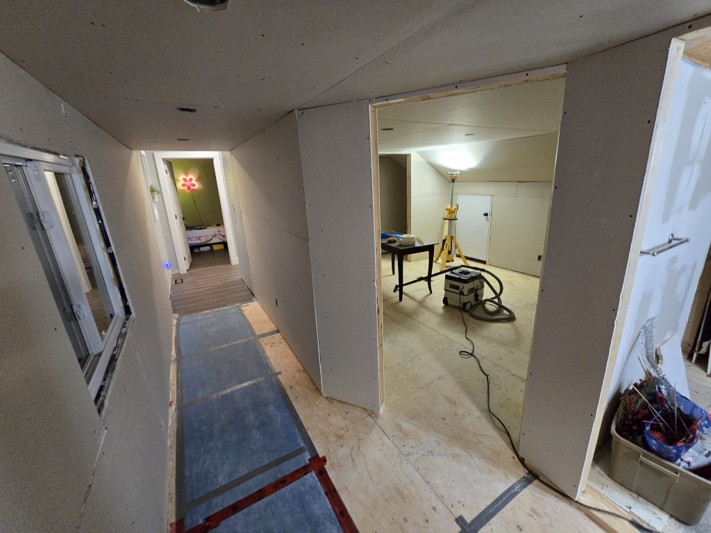 Installing drywall in a hallway.
