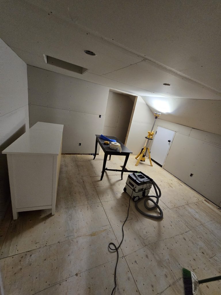 Finishing drywall installation in a room.